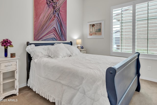 bedroom with light colored carpet and baseboards