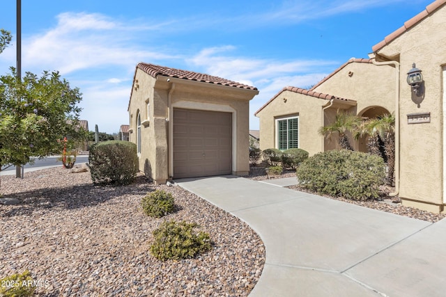 mediterranean / spanish home featuring stucco siding, driveway, and a tile roof