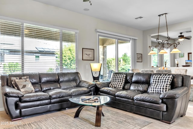 living room with light tile patterned flooring, a ceiling fan, and visible vents