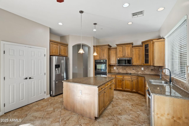 kitchen featuring a center island, sink, backsplash, pendant lighting, and black appliances