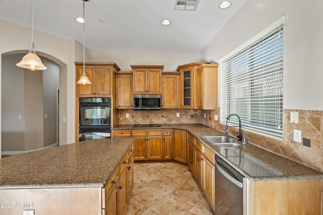 kitchen with sink, hanging light fixtures, stainless steel appliances, backsplash, and dark stone countertops