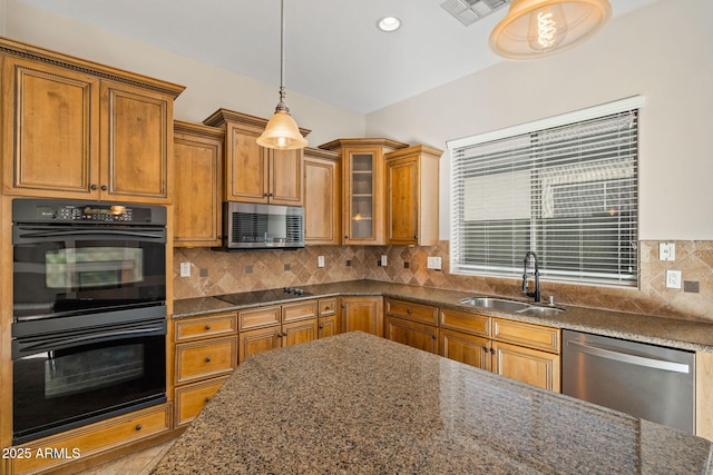 kitchen featuring pendant lighting, sink, dark stone countertops, and black appliances