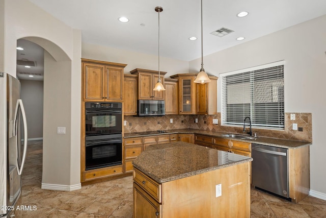 kitchen with a center island, sink, hanging light fixtures, decorative backsplash, and black appliances