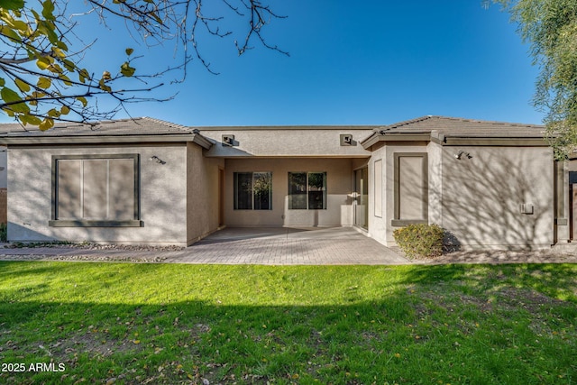 rear view of property featuring a patio and a lawn