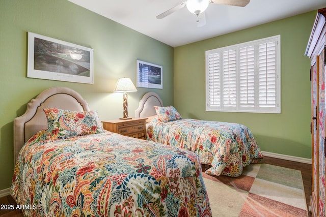 bedroom featuring baseboards, wood finished floors, and a ceiling fan