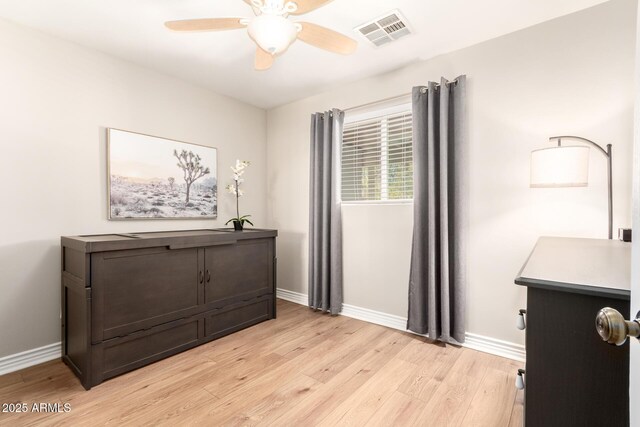 interior space featuring baseboards, visible vents, light wood-style floors, and a ceiling fan