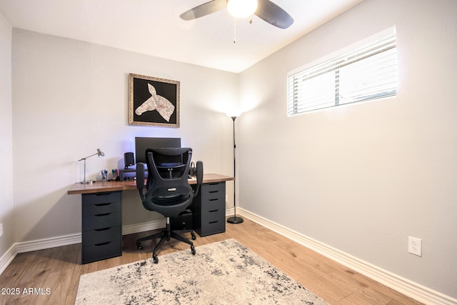 home office with baseboards, light wood-style flooring, and a ceiling fan