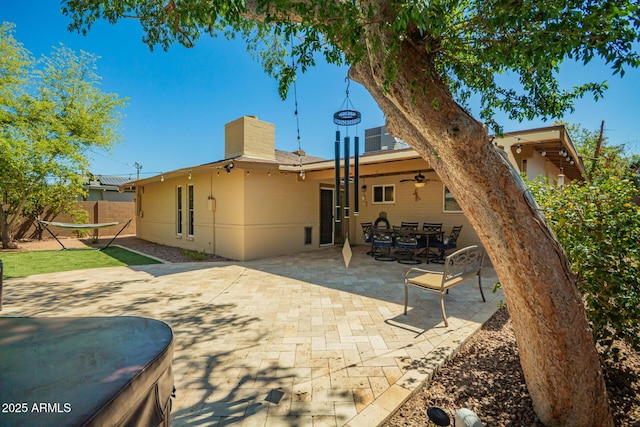 rear view of property featuring a ceiling fan, a patio area, fence, and a chimney
