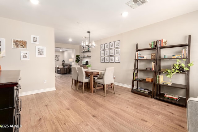 dining area featuring baseboards, visible vents, light wood-style floors, recessed lighting, and an inviting chandelier