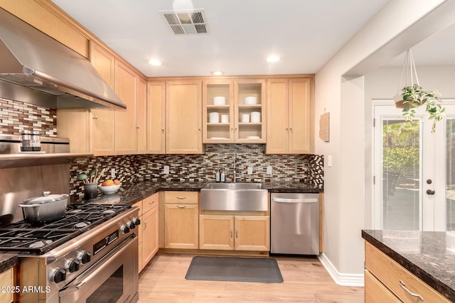 kitchen with visible vents, light brown cabinetry, appliances with stainless steel finishes, and extractor fan