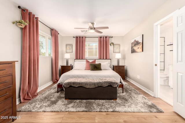 bedroom featuring baseboards, multiple windows, and light wood-type flooring