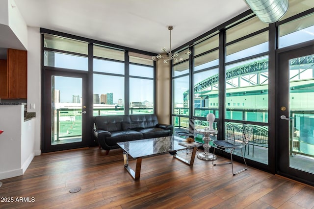 living room with dark hardwood / wood-style flooring, floor to ceiling windows, and a chandelier