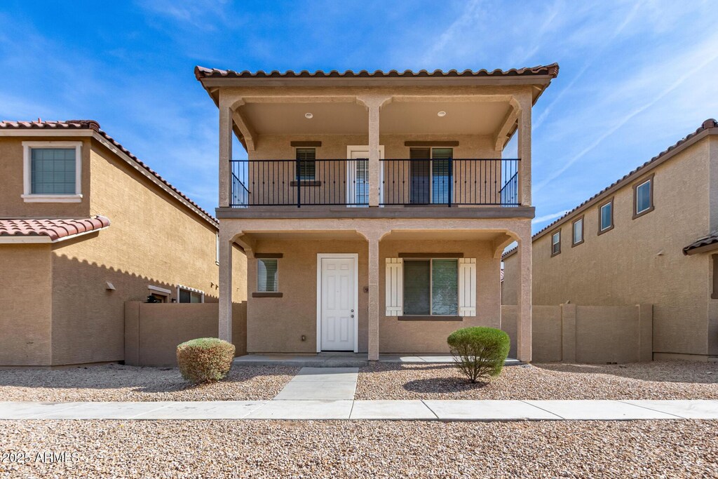 907 E Agua Fria Ln, Avondale, AZ 85323 - view of front of property with a balcony, covered porch, fence, and stucco siding