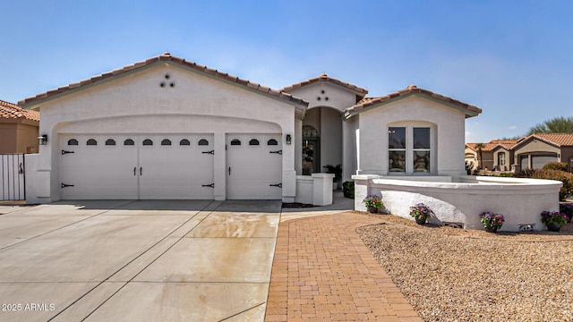 mediterranean / spanish-style house with a garage, a tile roof, driveway, and stucco siding