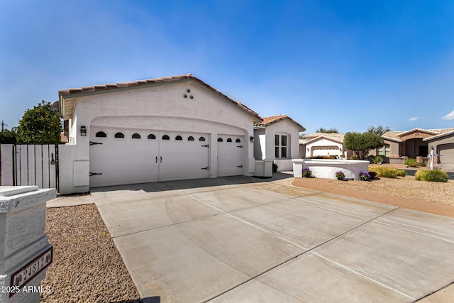 view of front facade featuring concrete driveway, a tiled roof, an attached garage, and stucco siding