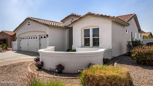 mediterranean / spanish home with a garage, concrete driveway, and stucco siding