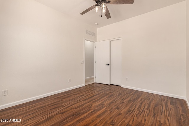 empty room featuring visible vents, baseboards, ceiling fan, and dark wood-type flooring