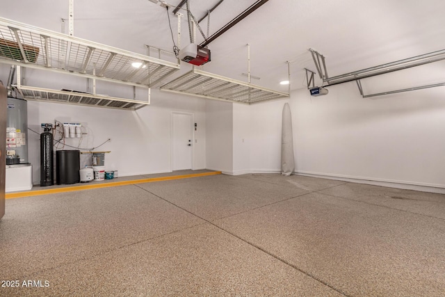 garage featuring a garage door opener, water heater, and baseboards