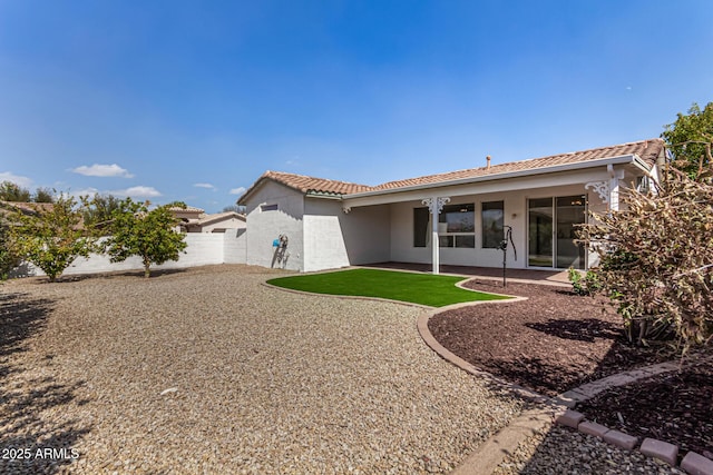 rear view of property featuring a tile roof, fence, a patio, and stucco siding