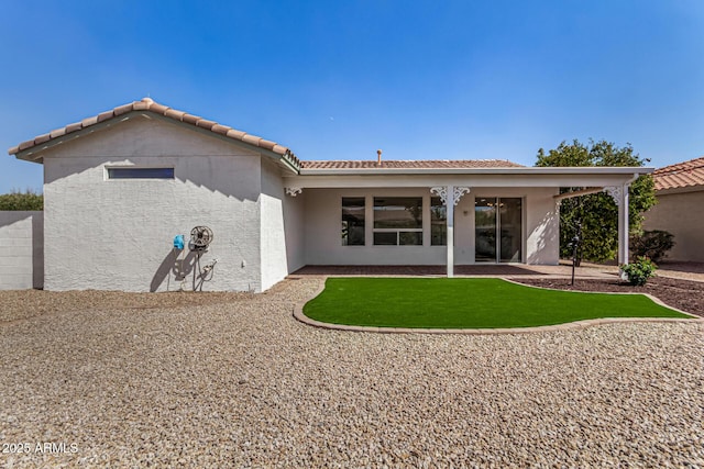 rear view of property with a patio, a tiled roof, and stucco siding