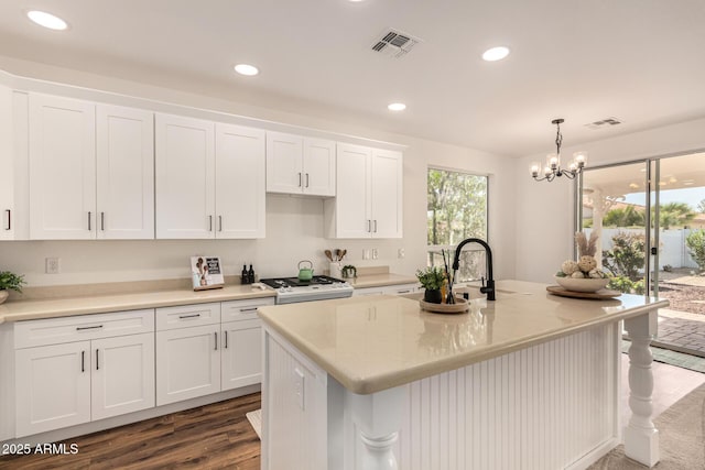 kitchen featuring white cabinets, visible vents, range, and recessed lighting