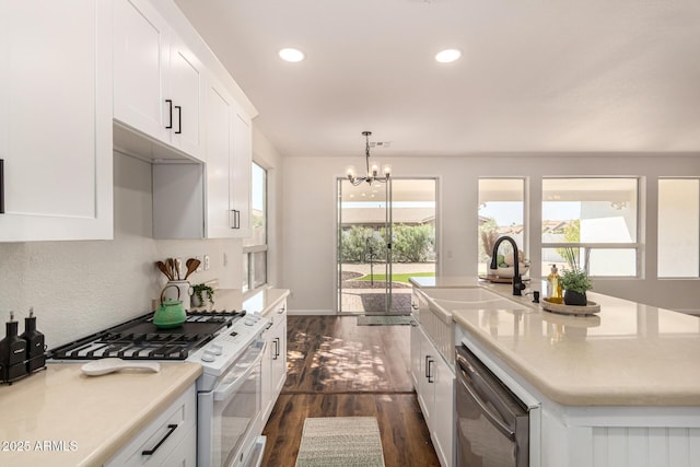 kitchen with white cabinets, light countertops, dishwasher, gas range gas stove, and a center island with sink