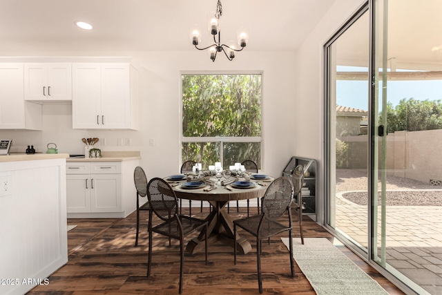 dining area featuring a notable chandelier, dark wood-type flooring, and recessed lighting