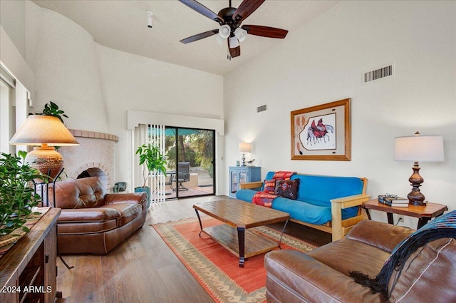 living room featuring ceiling fan, high vaulted ceiling, and wood-type flooring