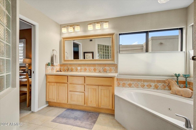 bathroom featuring a bathing tub, tile patterned flooring, and vanity