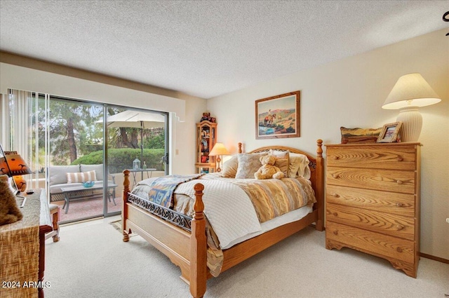 carpeted bedroom featuring a textured ceiling and access to outside