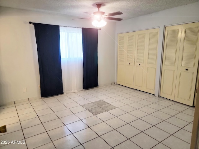 7525 W Turney Ave, Phoenix, AZ 85033 - unfurnished bedroom with a textured ceiling, multiple closets, and a ceiling fan