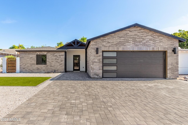 view of front of home with brick siding, decorative driveway, and a garage