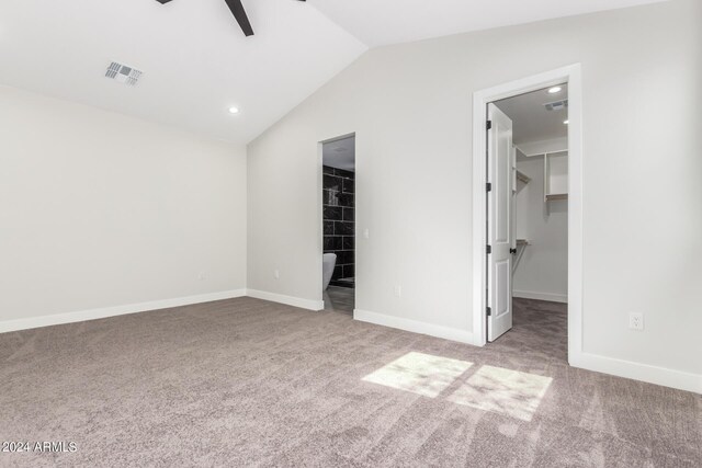 unfurnished bedroom featuring vaulted ceiling, light carpet, a closet, a spacious closet, and ceiling fan