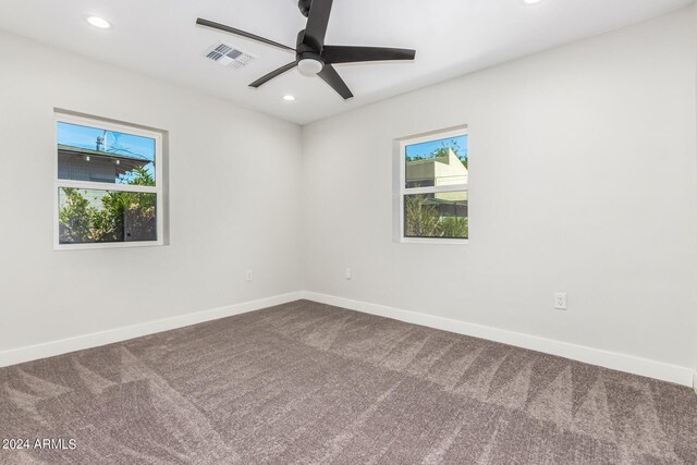 spare room with ceiling fan and carpet