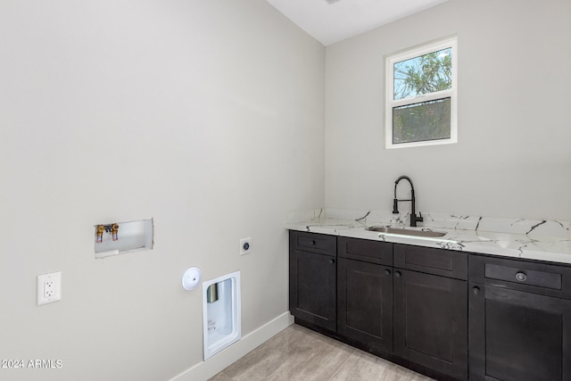 washroom with cabinets, washer hookup, sink, hookup for an electric dryer, and light hardwood / wood-style floors