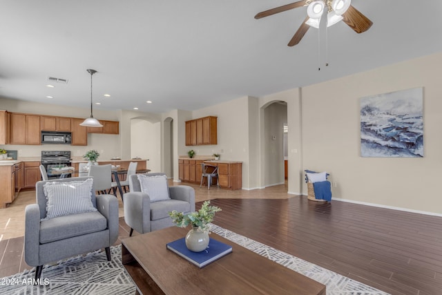 living room with ceiling fan and light hardwood / wood-style floors