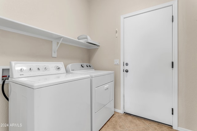 laundry area with light tile patterned floors and washing machine and clothes dryer