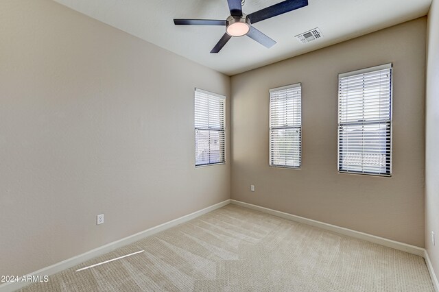 spare room with ceiling fan and light colored carpet