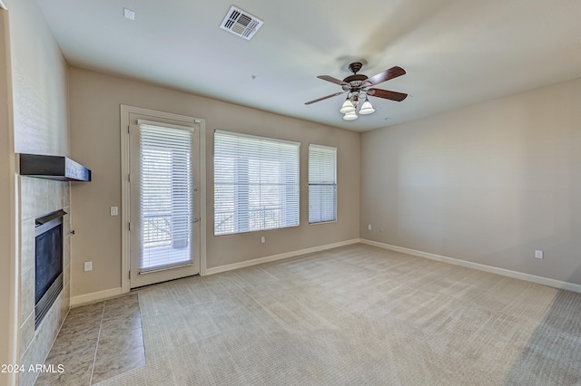 unfurnished living room with light carpet, a fireplace, and ceiling fan