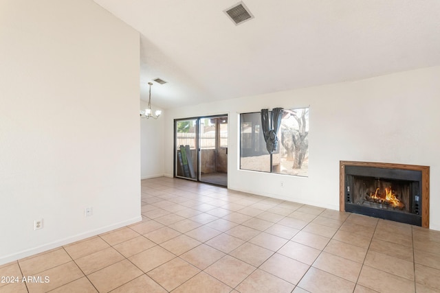 unfurnished living room featuring a chandelier, light tile patterned floors, and vaulted ceiling