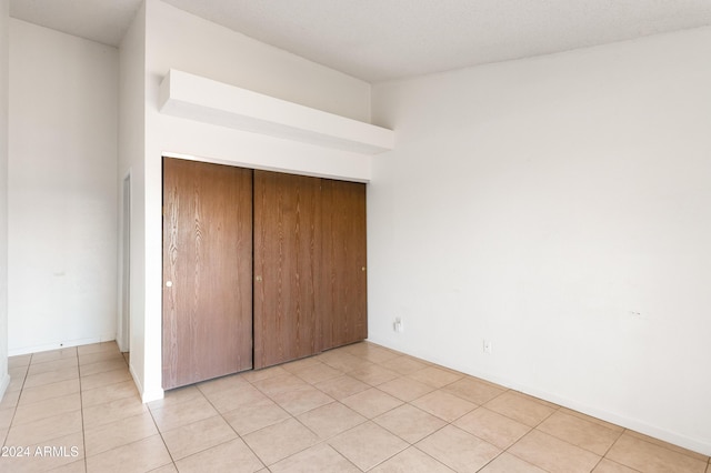 unfurnished bedroom featuring a closet and light tile patterned floors