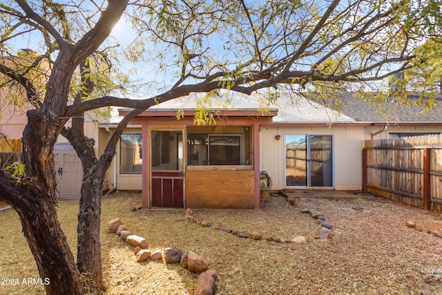 rear view of house featuring a shed