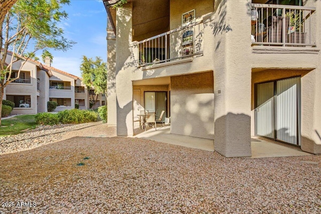 9450 N 94th Pl Unit 106, Scottsdale, AZ 85258 - back of property with stucco siding, a balcony, and a patio