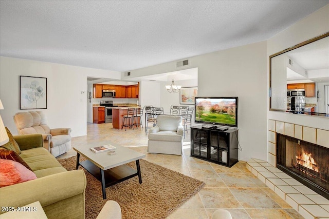 9450 N 94th Pl Unit 106, Scottsdale, AZ 85258 - living area featuring a chandelier, a fireplace, and a textured ceiling