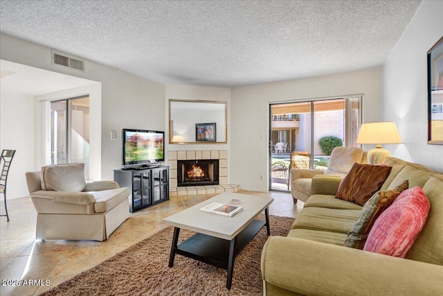 9450 N 94th Pl Unit 106, Scottsdale, AZ 85258 - living area featuring a tiled fireplace and a textured ceiling