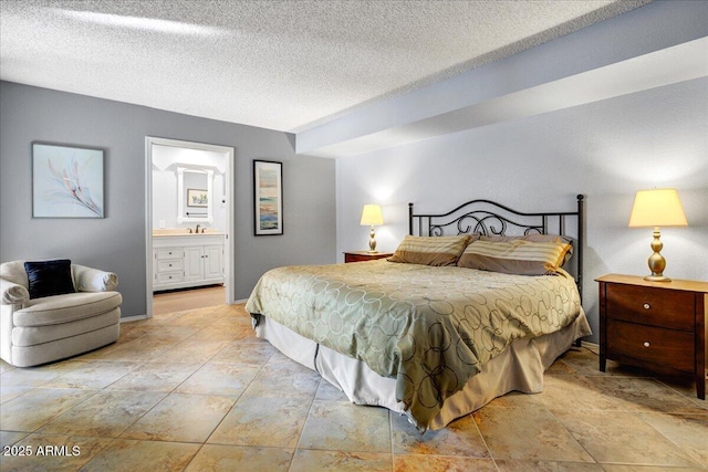 9450 N 94th Pl Unit 106, Scottsdale, AZ 85258 - bedroom featuring a textured ceiling, ensuite bathroom, and a sink