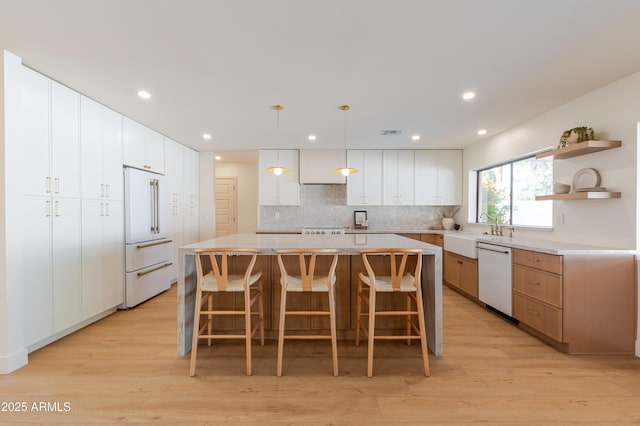 7127 N 79th St, Scottsdale, AZ 85258 - kitchen with white appliances, a sink, light wood-style floors, a kitchen island, and a kitchen breakfast bar