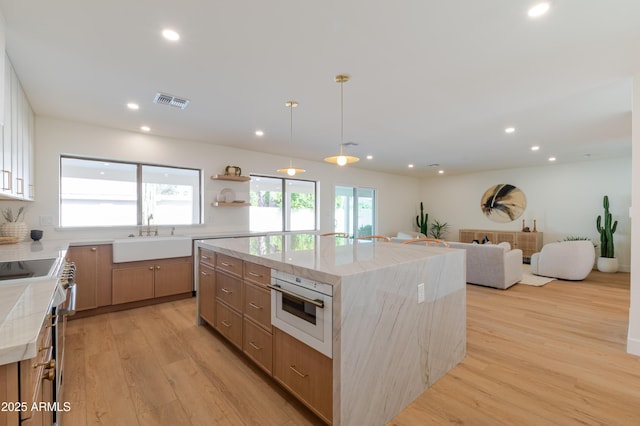 7127 N 79th St, Scottsdale, AZ 85258 - kitchen featuring a sink, white oven, a large island, light wood finished floors, and recessed lighting