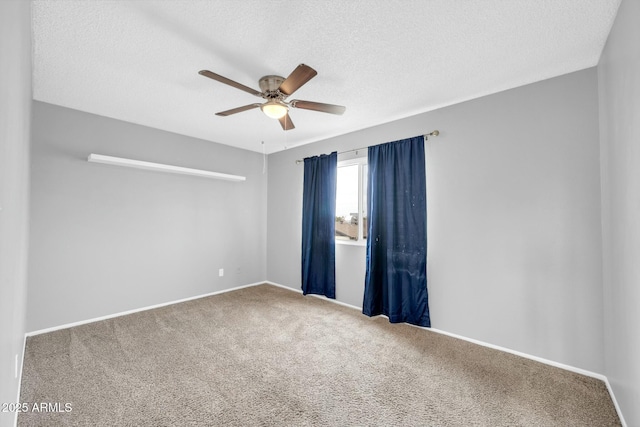 spare room featuring carpet, baseboards, ceiling fan, and a textured ceiling