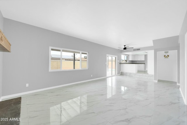 unfurnished living room with visible vents, marble finish floor, a ceiling fan, and baseboards